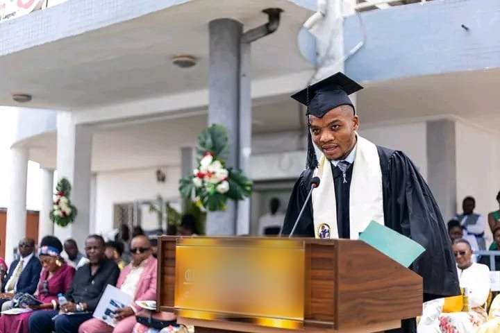 Apprenant de Merlo Skills Group en toge et toque, prenant la parole lors d'une cérémonie de remise de diplôme.